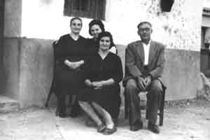 Grupo sentado en la puerta de casa. Mainar.