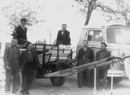 Grupo de hombres junto a un carro.