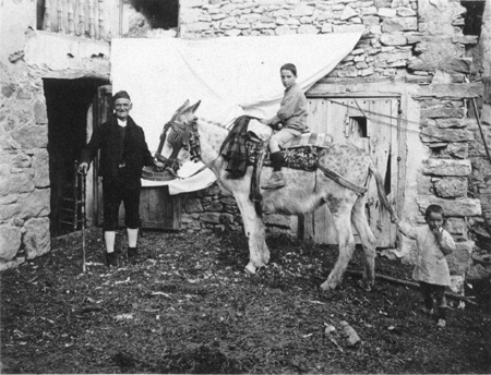 Abuelo y nieto sobre un burro. Blancas.