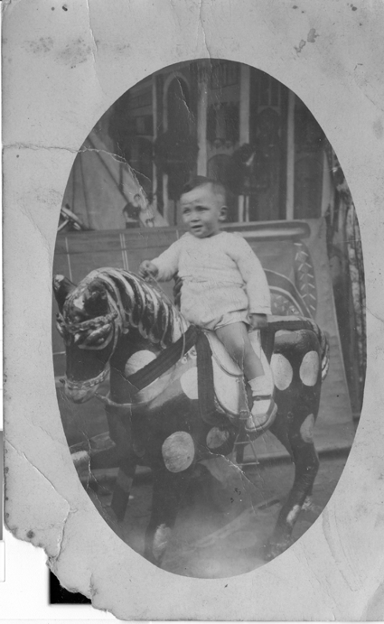 NiÃ±o montado sobre caballito de madera con lunares. BurbÃ¡guena