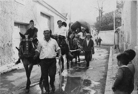 Dos carromatos con gente en una calle de Calamocha.