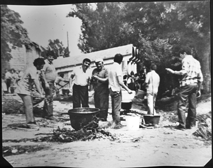 Grupo de hombres guisando el toro. Cosa