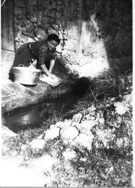 Una mujer lavando en el campo. Fuentes Claras.