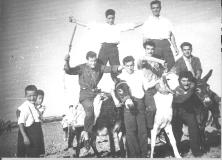 Grupo de jÃ³venes sobre burros divirtiÃ©ndose en el campo. Loscos.