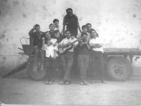 Grupo de jÃ³venes junto a un carro. Loscos.