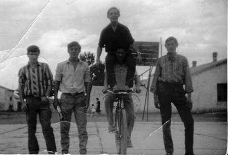 Retrato de cinco jÃ³venes, dos de ellos sobre una bicicleta. Ojos Negros.