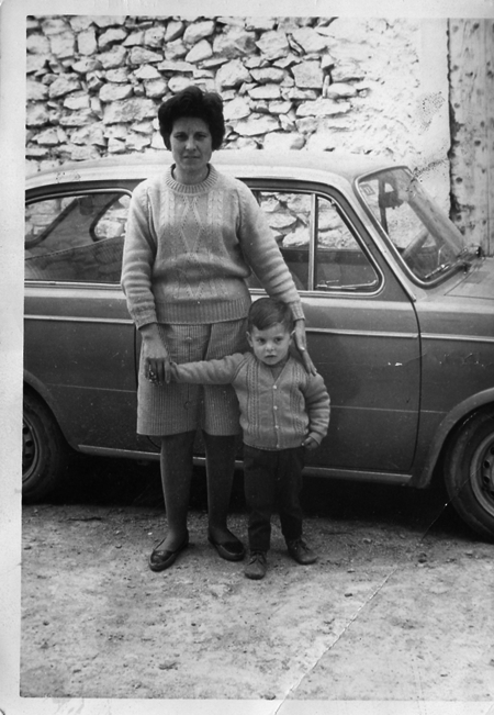 Una madre con su hijo junto a un coche. Torralba de los Sisones.