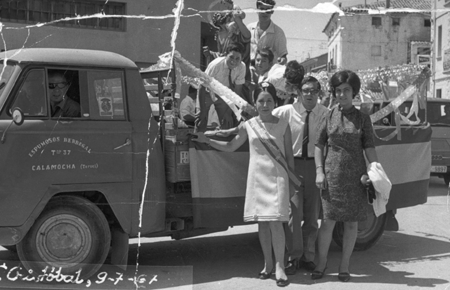 Grupo de personas sobre un coche en la fiestas de San Cristobal.
