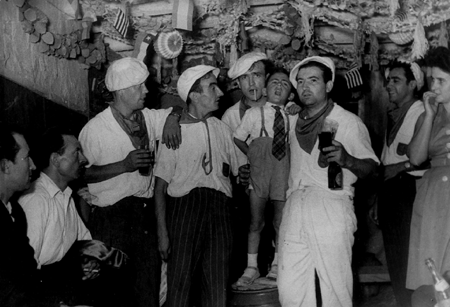 Grupo de hombres fumando y bebiendo en las fiestas de San Roque. Calamocha.