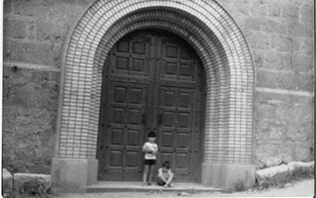 Dos niÃ±os junto a la puerta de la iglesia de Villahermosa.