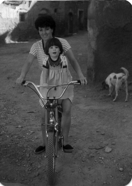 Mujer y niÃ±a sobre una bicicleta. Monforte.