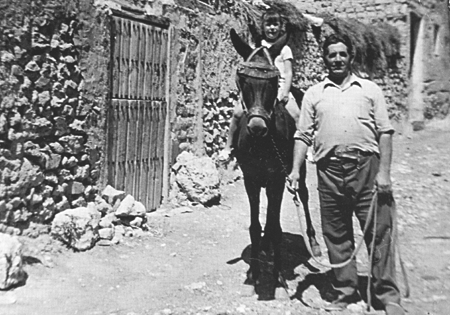 Tuto Serrano dando un paseo en burro a su sobrina por las calles de Langa del Castillo.