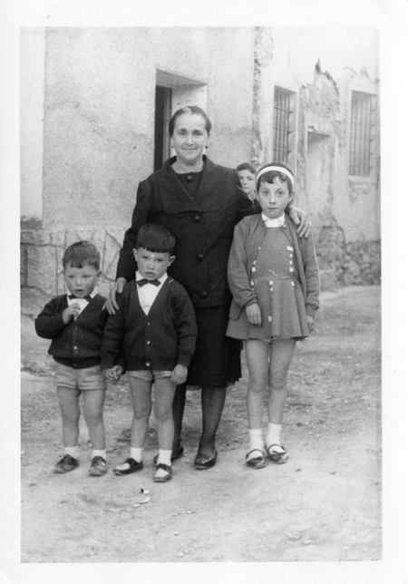 Vecina de Cuencabuena junto a un grupo de niÃ±os.