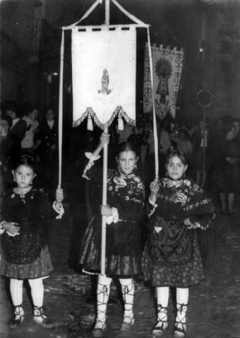 NiÃ±as vestidas con el traje regional y portando un estandarte. Maluenda.