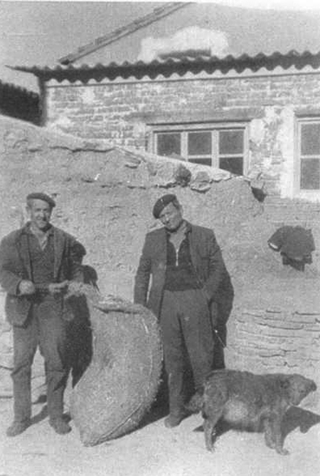 Dos vecinos de Morata de Jiloca cargando un saco.