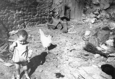 Un bebÃ© junto a una gallina en Morata de Jiloca.
