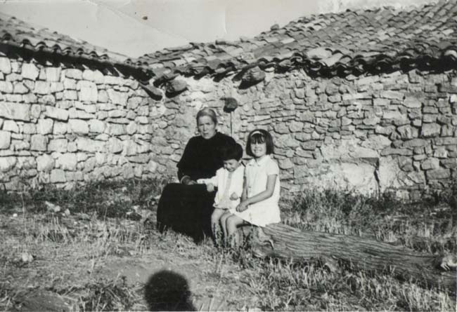 Anciana y niÃ±os sentados en un tronco